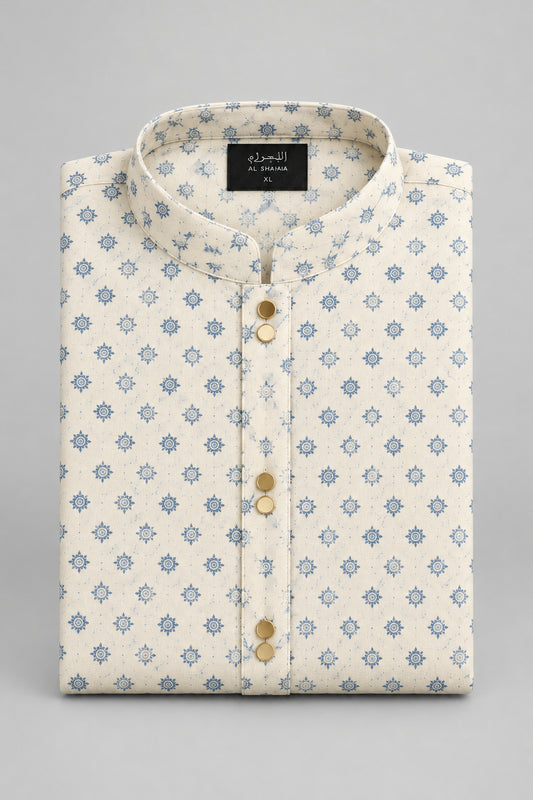 A folded cream-colored shirt with a light blue star pattern, featuring a button-down front and a black size tag, laid flat on a gray surface.