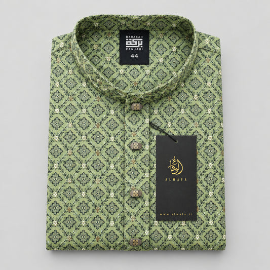 A folded men's shirt with a green and beige geometric pattern, displayed on a light wood table. The shirt features a band collar, button-down front, and a black hangtag with the brand name 'KINSHA'.