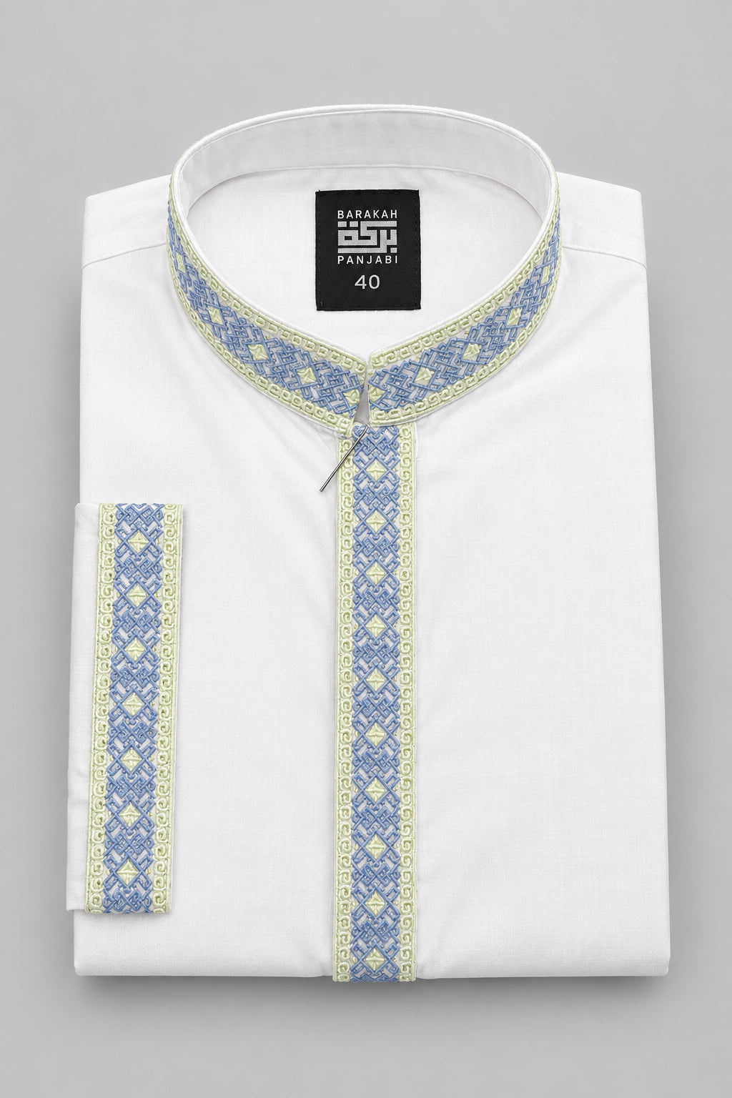 A folded white kurta shirt with blue and yellow patterned trim, featuring a mandarin collar and a black hangtag, displayed on a dark blue surface.