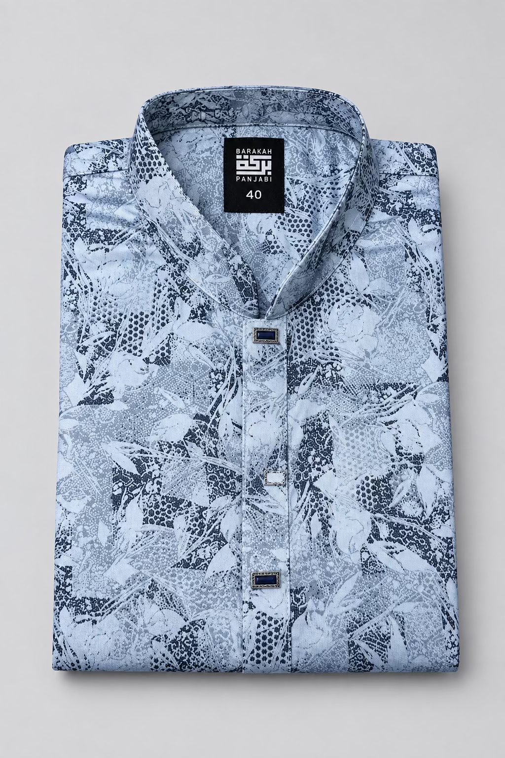 A folded men's long-sleeve shirt with a black and white abstract pattern, featuring a black neck label that reads 'BESPOKE PARACHUT' and '40', and a black hangtag with a gold logo.
